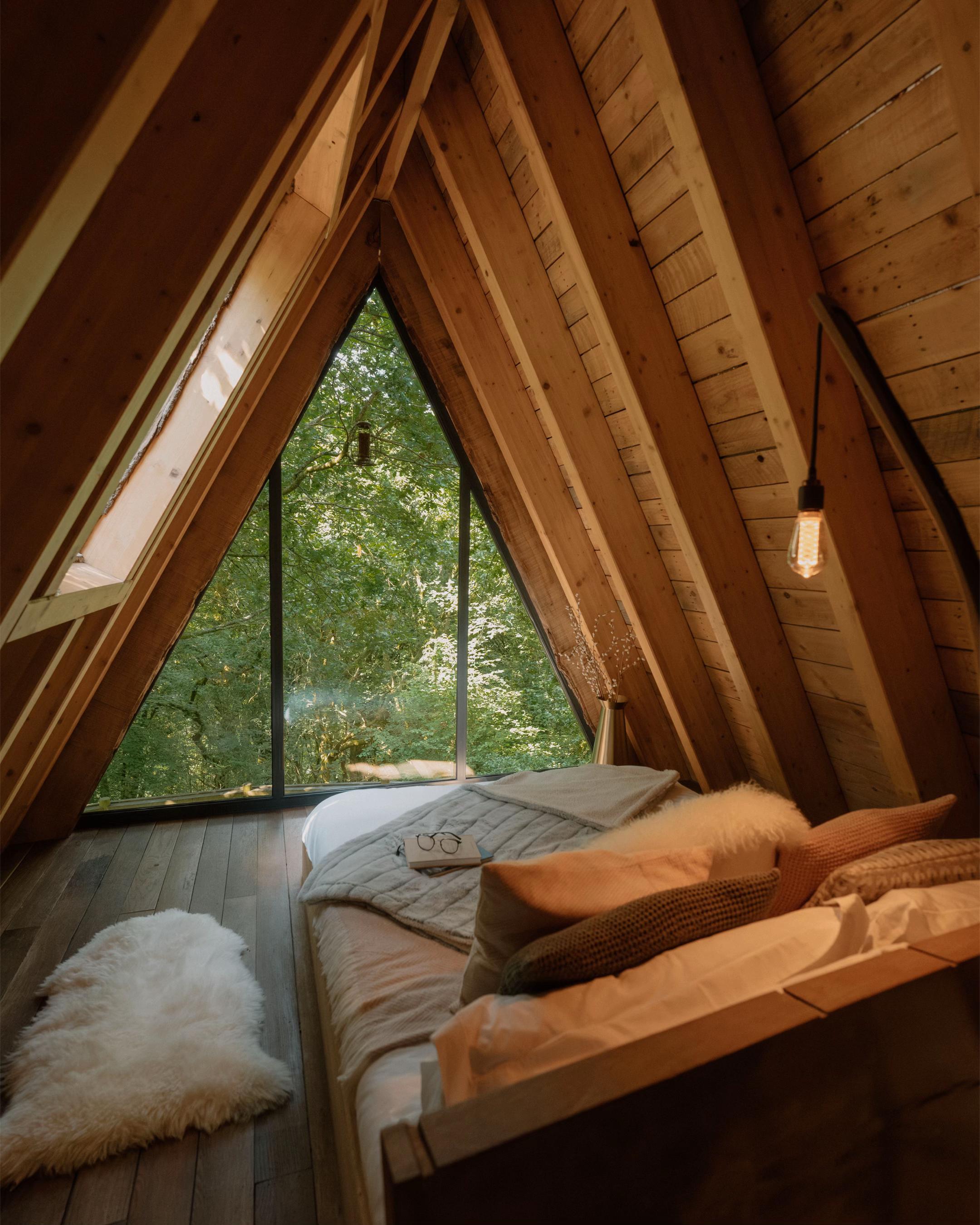 A-frame bedroom beneath warm timber rafters